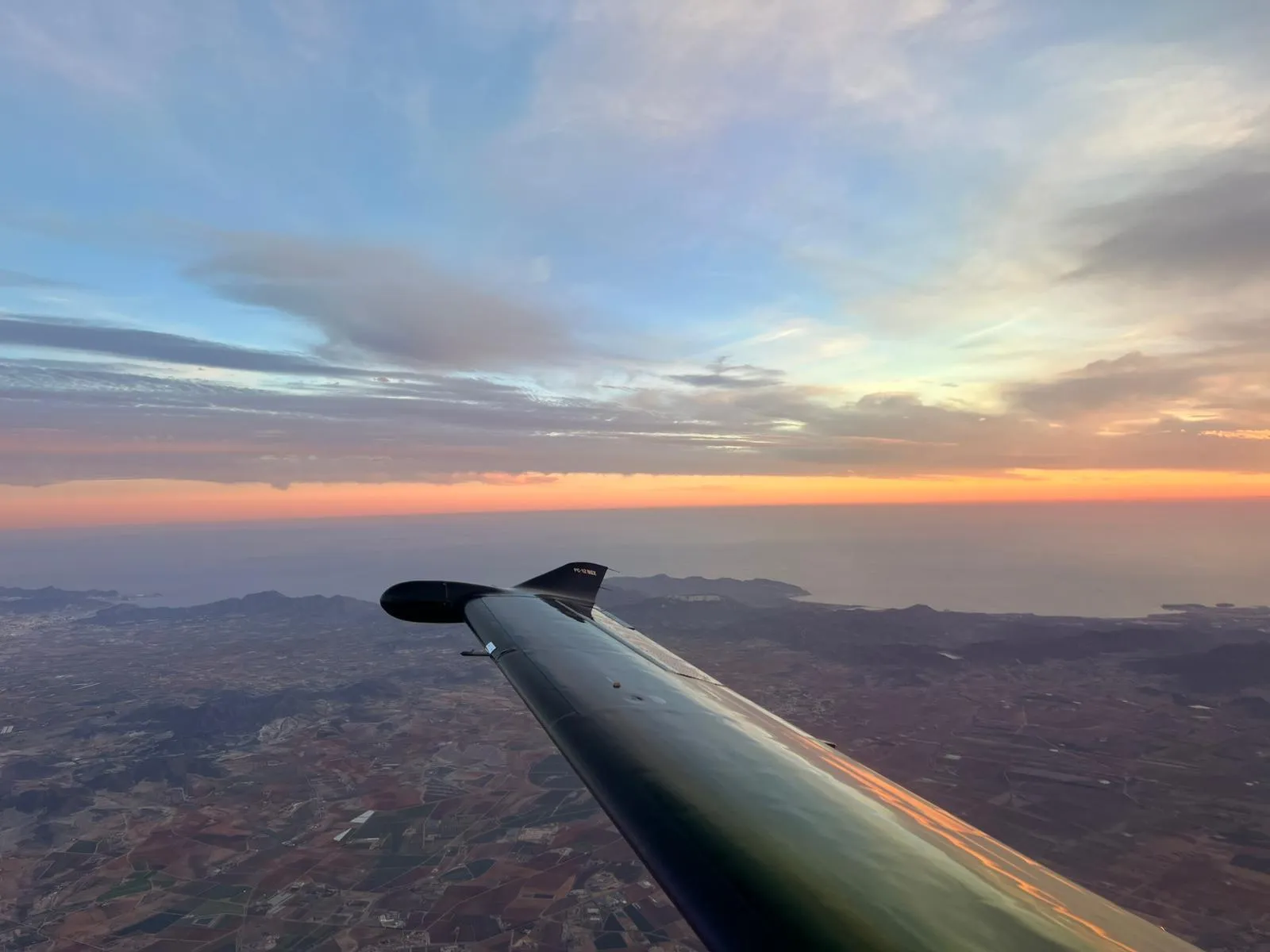 Tragfläche im Abendlicht über den Wolken