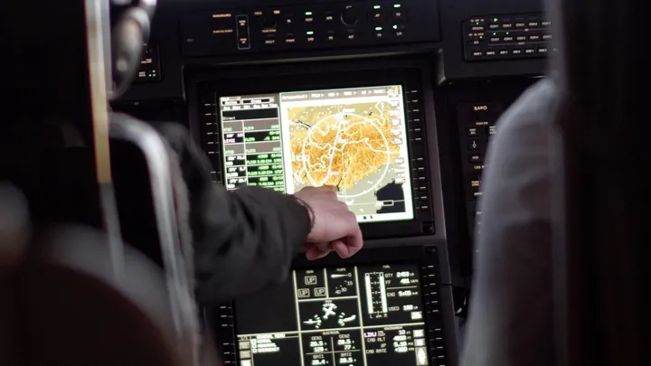 Pilot zeigt im Cockpit der Pilatus PC-12 NGX auf die Navigationsanzeige